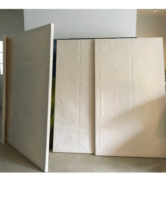 Three large, blank hand-stretched canvases standing in Laurie Rubell’s studio before painting.